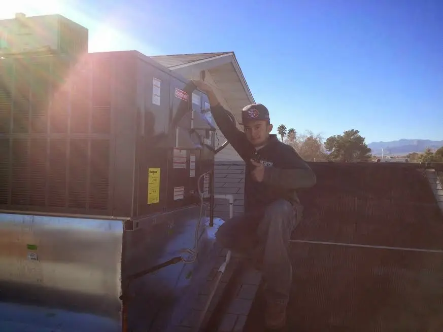 HVAC technician performing Heat Pump Repair on a rooftop unit in Rohnert Park